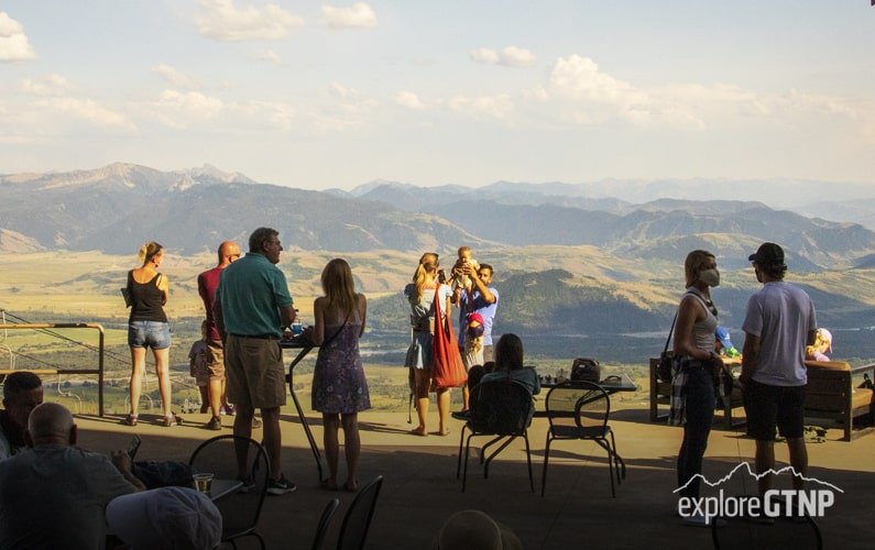 Grand Teton - The Deck at Piste - Couple taking picture of their baby with Jackson Hole Valley in the background