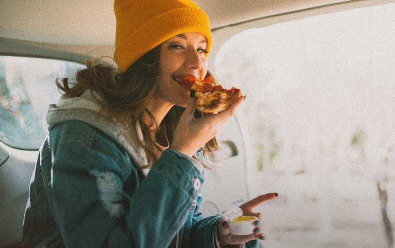 Girl Eating Pizza in the Car