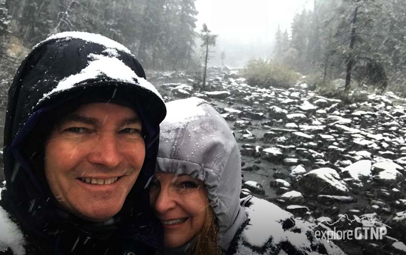 couple on String Lake foot bridge in Grand Teton on October 1st - snowing