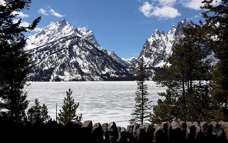 Jenny Lake covered in snow with Tetons in the background